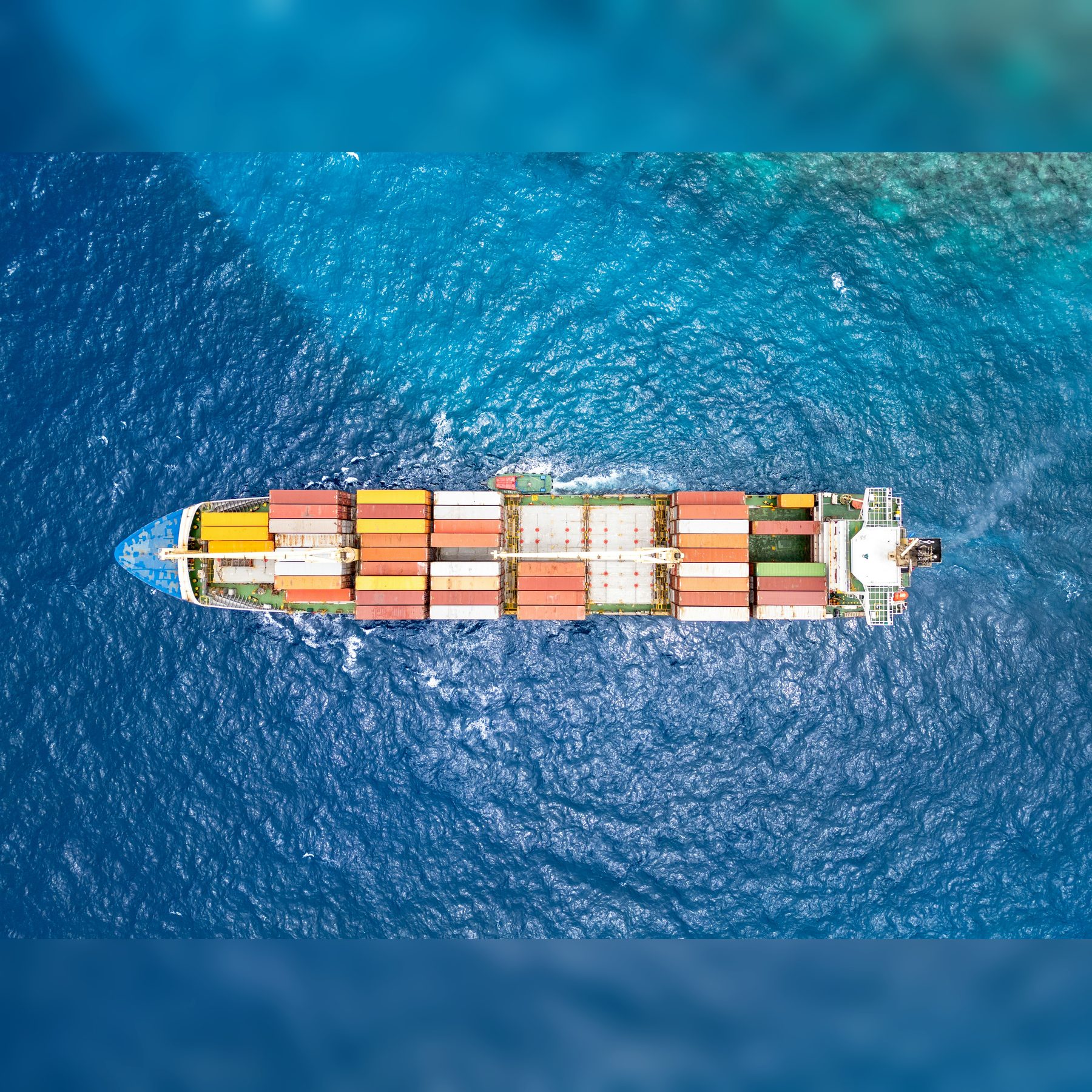 Aerial view of a cargo ship crossing blue ocean